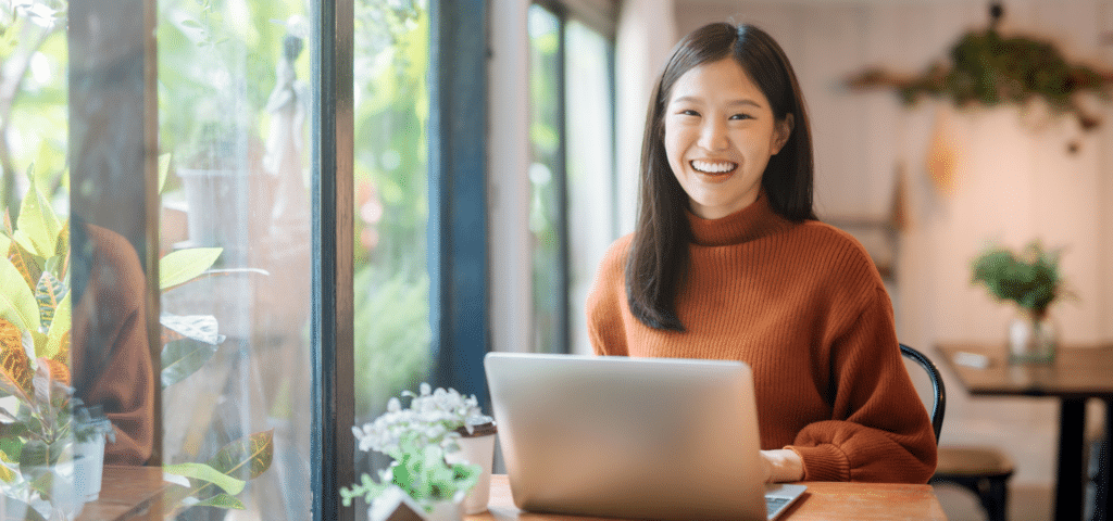 woman smiling in front of laptop
