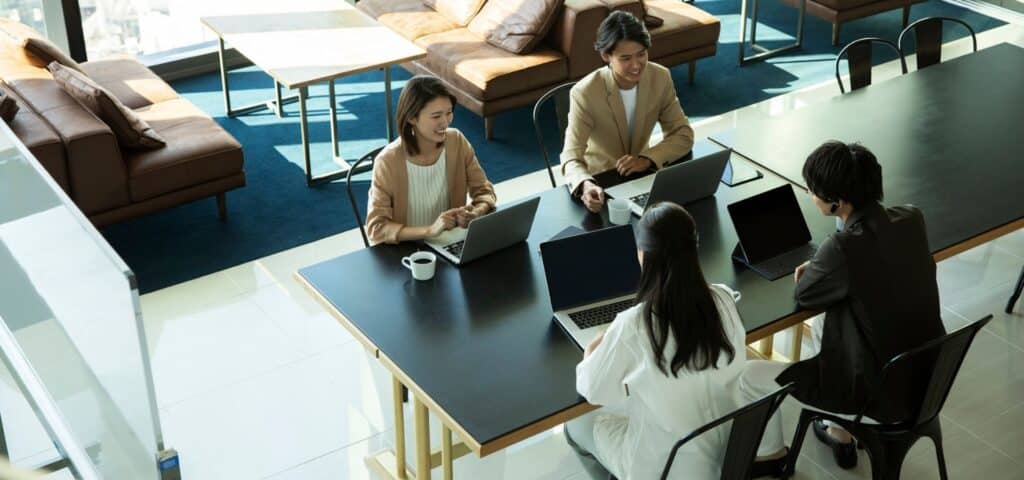 overhead shot of team working at table together on laptops